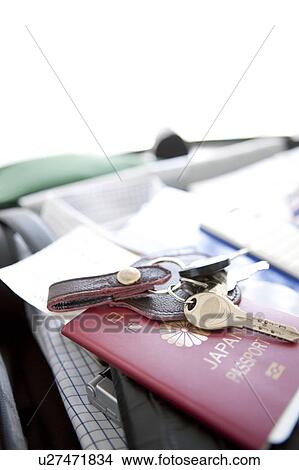 Picture - Passport and keys on top of a packed suitcase. Fotosearch