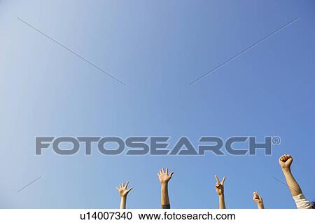 Stock Image - Peoples hands making rock paper scissors gestures. Fotosearch