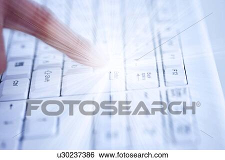 Stock Photograph - Person typing on keyboard with solar flare radiating from finger. Fotosearch