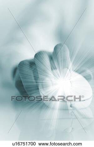 Stock Image - Person using computer mouse with solar flare radiating from finger. Fotosearch