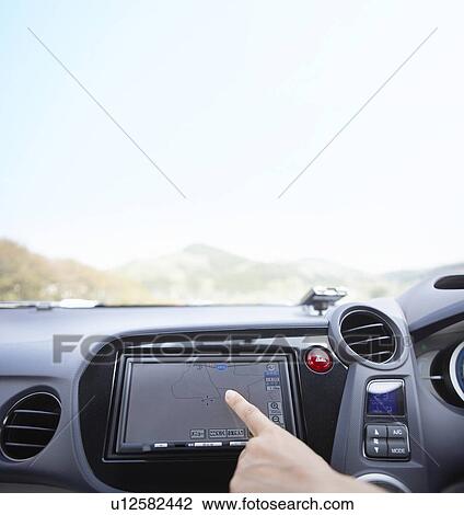 Stock Image - Person using GPS in a car. Fotosearch