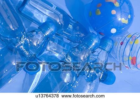 Stock Photo - Plastic bottles, balloons and balls floating in a paddling pool. Fotosearch