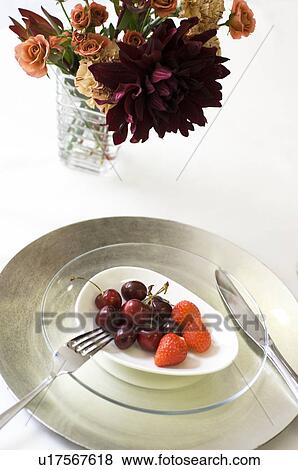 Stock Photo - Plate of fruit and vase of flowers. Fotosearch