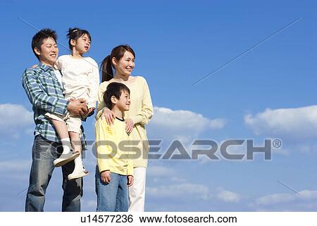 Portrait of a family of four against a blue sky View Large Photo Image Stock Photograph - Portrait of a family of four against a blue sky. Fotosearch