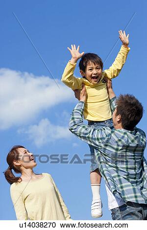 Portrait of a family with young son playing against a blue sky View Large Photo Image Stock Image - Portrait of a family with young son playing against a blue sky. Fotosearch
