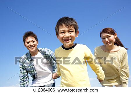 Portrait of a family with young son holding hands against a blue sky View Large Photo Image Stock Photograph - Portrait of a family with young son holding hands against a blue sky. Fotosearch