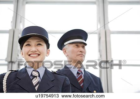Stock Image - Portrait of smiling guards in building. Fotosearch