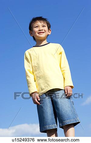 Stock Photograph - Portrait of young boy against a blue sky. Fotosearch