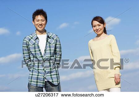 Stock Photo - Portrait of young couple against a blue sky. Fotosearch