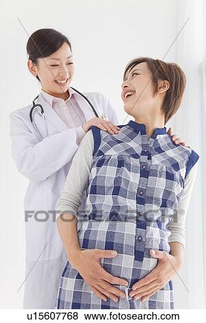 Stock Photo - Pregnant woman having check up with gynecologist. Fotosearch