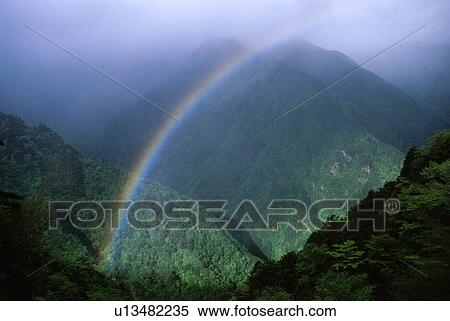 Stock Photography - Rainbow over green mountains. Fotosearch