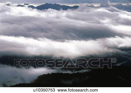 Sea of clouds over a mountain range View Large Photo Image Stock Image - Sea of clouds over a mountain range. Fotosearch