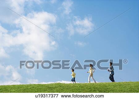 Side view of a family with young son running in the park against a blue sky View Large Photo Image Stock Photo - Side view of a family with young son running in the park against a blue sky. Fotosearch