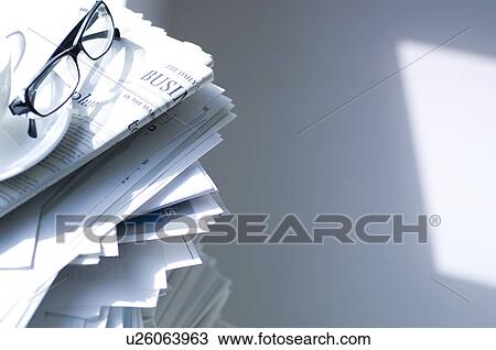 Stock Image - Spectacles on a stack of documents. Fotosearch