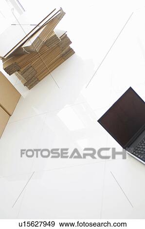 Stock Photo - Stack of cardboard boxes and a laptop. Fotosearch