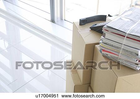 Stock Image - Stack of cardboard boxes and magazines. Fotosearch