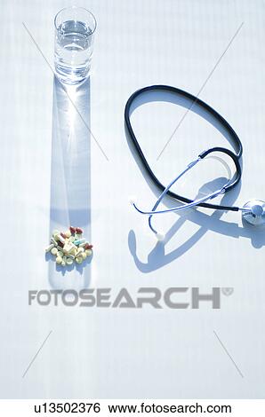Stock Photograph - Stethoscope, glass of water and pills. Fotosearch