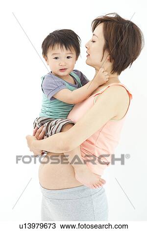Studio portrait of pregnant woman hugging her preschool age son View Large Photo Image Stock Image - Studio portrait of pregnant woman hugging her preschool age son. Fotosearch