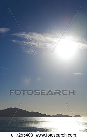 Stock Image - Sun shining brightly over seascape. Fotosearch