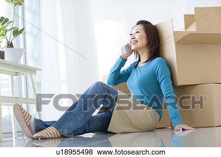 Stock Photo - The woman under move work about which it speaks with a mobile phone. Fotosearch