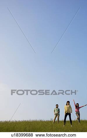 Stock Photo - Three female friends in a field. Fotosearch