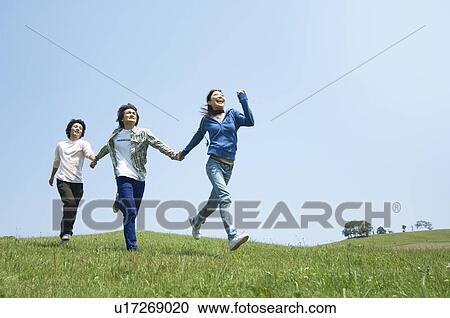 Three young people holding hands running View Large Photo Image Stock Image - Three young people holding hands running. Fotosearch