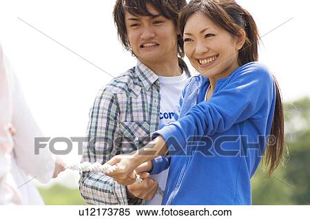 Three young people playing tug-of-war View Large Photo Image Stock Photography - Three young people playing tug-of-war. Fotosearch