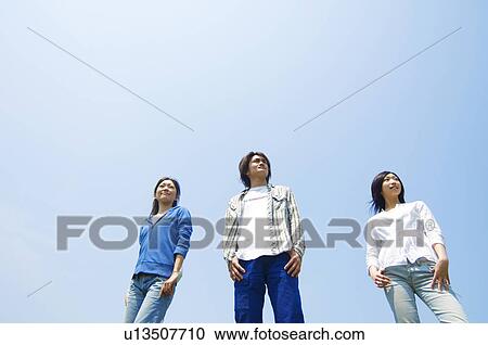 Three young people standing View Large Photo Image Stock Image - Three young people standing. Fotosearch