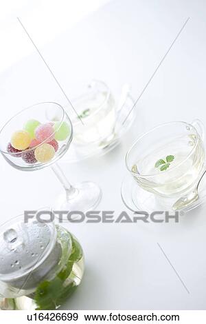 Two cups of herbal tea and a glass of candy View Large Photo Image Stock Photo - Two cups of herbal tea and a glass of candy. Fotosearch
