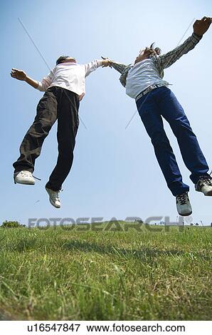 Stock Photo - Two young men doing a high five. Fotosearch