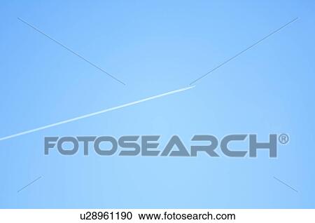 Stock Image - Vapor trail in a clear blue sky. Fotosearch