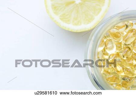 Stock Image - Vitamin capsules and a lemon. Fotosearch