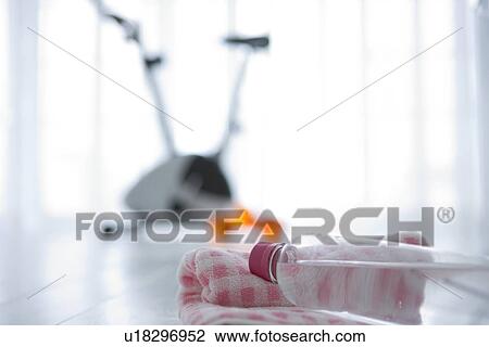 Stock Image - Water bottle and an exercise bike. Fotosearch