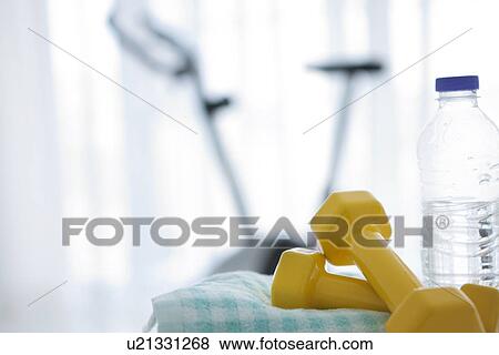 Stock Photo - Water bottle and an exercise bike. Fotosearch