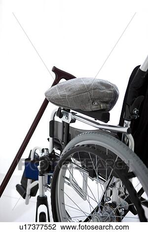 Stock Image - Wheelchair, cane and flat cap. Fotosearch