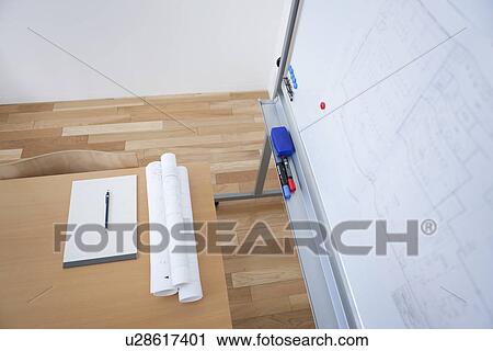 Stock Image - Whiteboard and blueprints in board room. Fotosearch