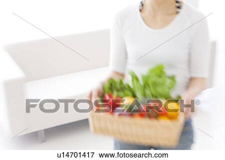 Woman carrying basket with fresh vegetables View Large Photo Image Stock Photo - Woman carrying basket with fresh vegetables. Fotosearch