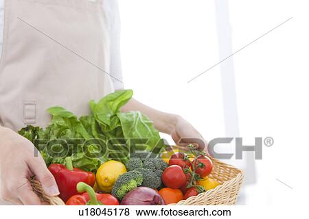 Woman carrying basket with fresh vegetables View Large Photo Image Stock Photo - Woman carrying basket with fresh vegetables. Fotosearch