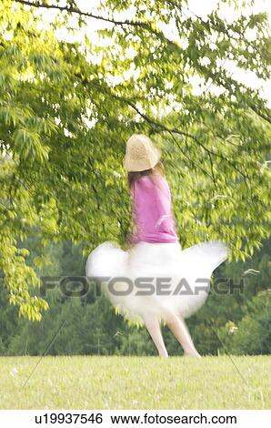 Stock Photograph - Woman dancing in a field. Fotosearch