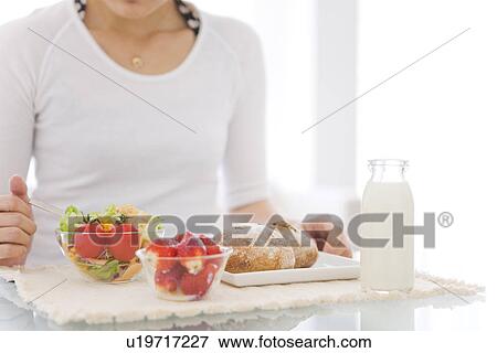 Woman eating meal of salad, strawberries and bread rolls View Large Photo Image Stock Photo - Woman eating meal of salad, strawberries and bread rolls. Fotosearch