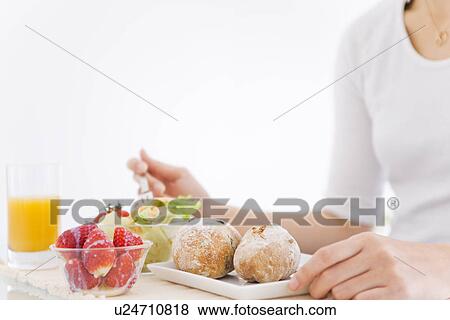 Woman eating meal of salad, strawberries and bread rolls View Large Photo Image Stock Photo - Woman eating meal of salad, strawberries and bread rolls. Fotosearch