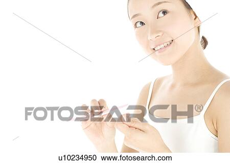 Stock Image - Woman filing her nails. Fotosearch
