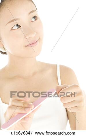 Woman filing her nails View Large Photo Image Stock Photo - Woman filing her nails. Fotosearch