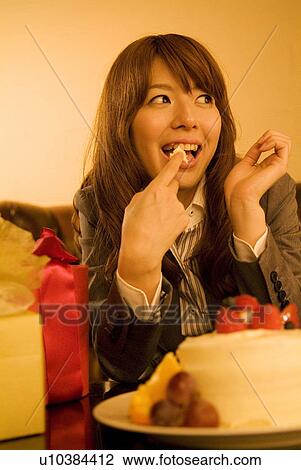 Woman having a sneaky taste of a cake View Large Photo Image Stock Image - Woman having a sneaky taste of a cake. Fotosearch