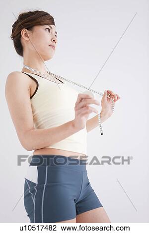 Woman holding a tape measure View Large Photo Image Stock Image - Woman holding a tape measure. Fotosearch