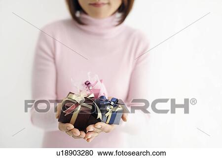 Stock Image - Woman holding gift boxes. Fotosearch