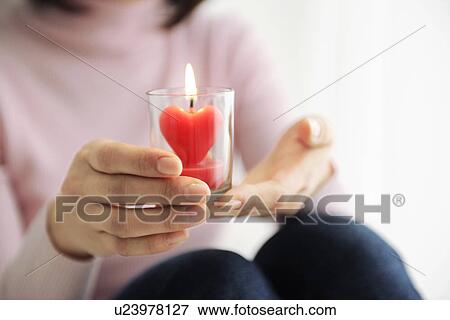 Woman holding heart shaped candle View Large Photo Image Stock Photo - Woman holding heart shaped candle. Fotosearch