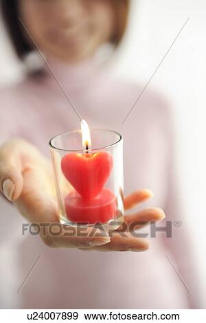 Woman holding heart shaped candle View Large Photo Image Stock Photo - Woman holding heart shaped candle. Fotosearch