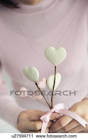 Woman holding heart shaped candy View Large Photo Image Stock Image - Woman holding heart shaped candy. Fotosearch