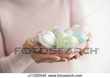 Stock Image - Woman holding heart shaped soaps. Fotosearch